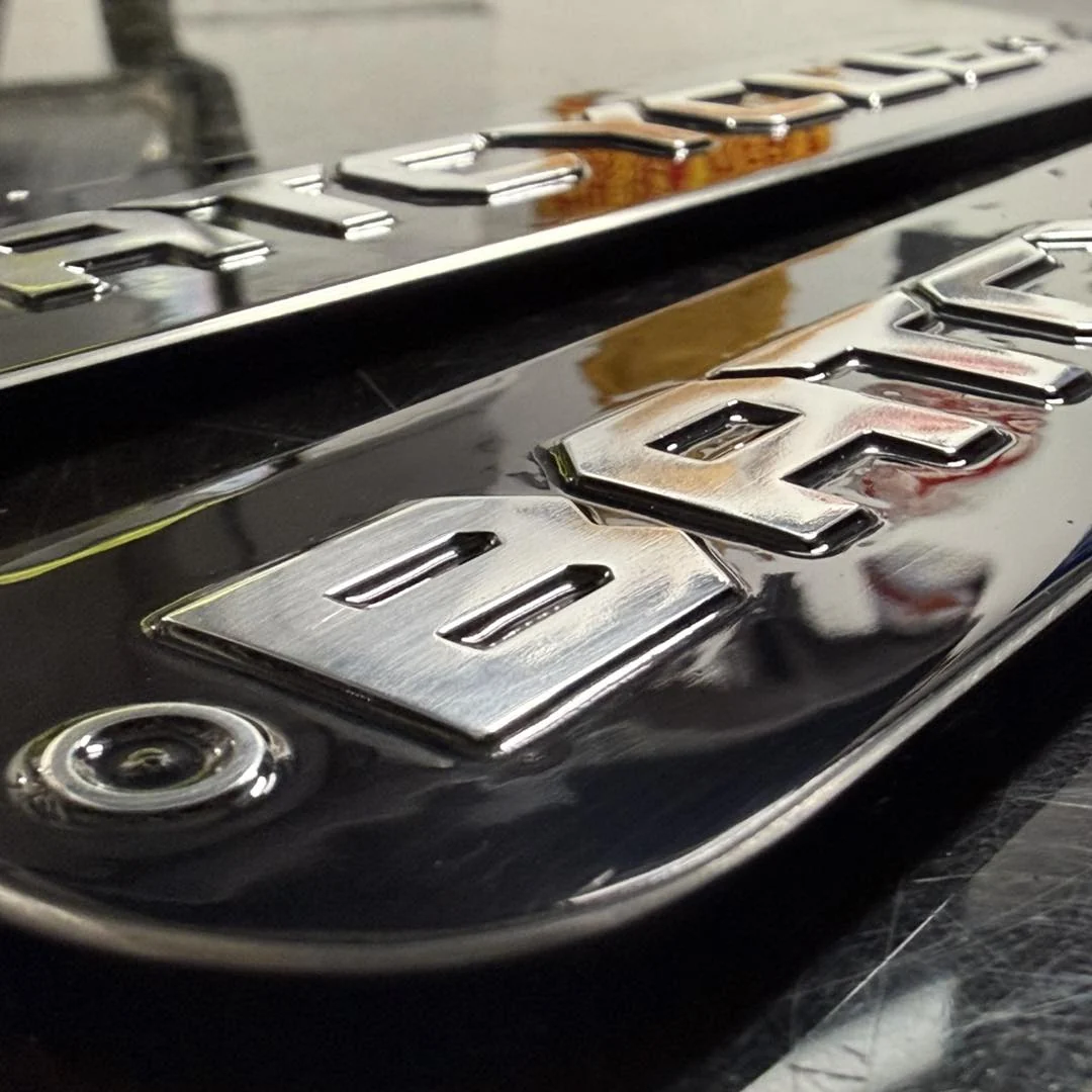 Close-up of a custom black and silver BMW R18 engine badge fitted to a motorcycle