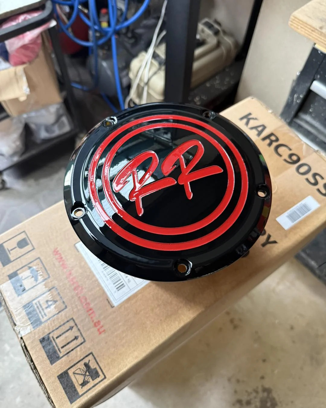 Black and red custom derby cover positioned on a shipping box before dispatch