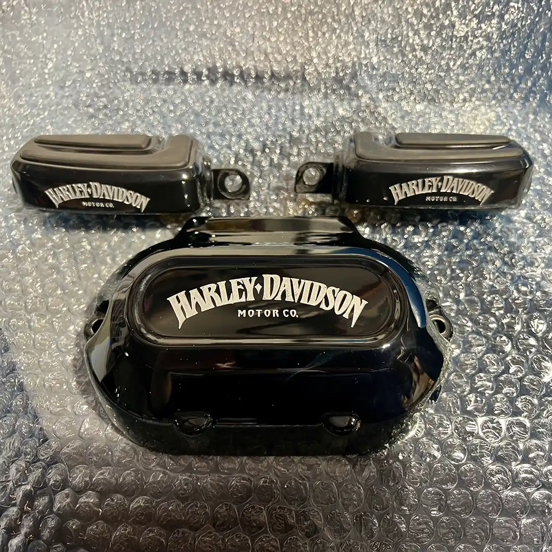 Matching black engraved motorcycle cover and foot pegs displayed together
