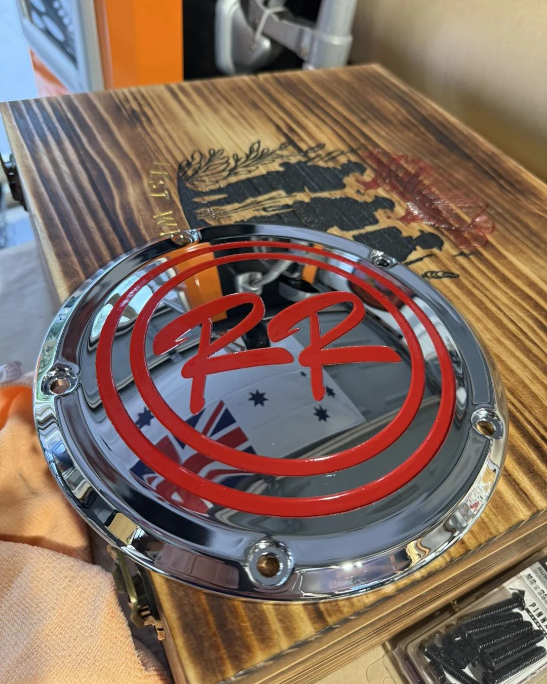 Chrome motorcycle derby cover with red and black custom engraving