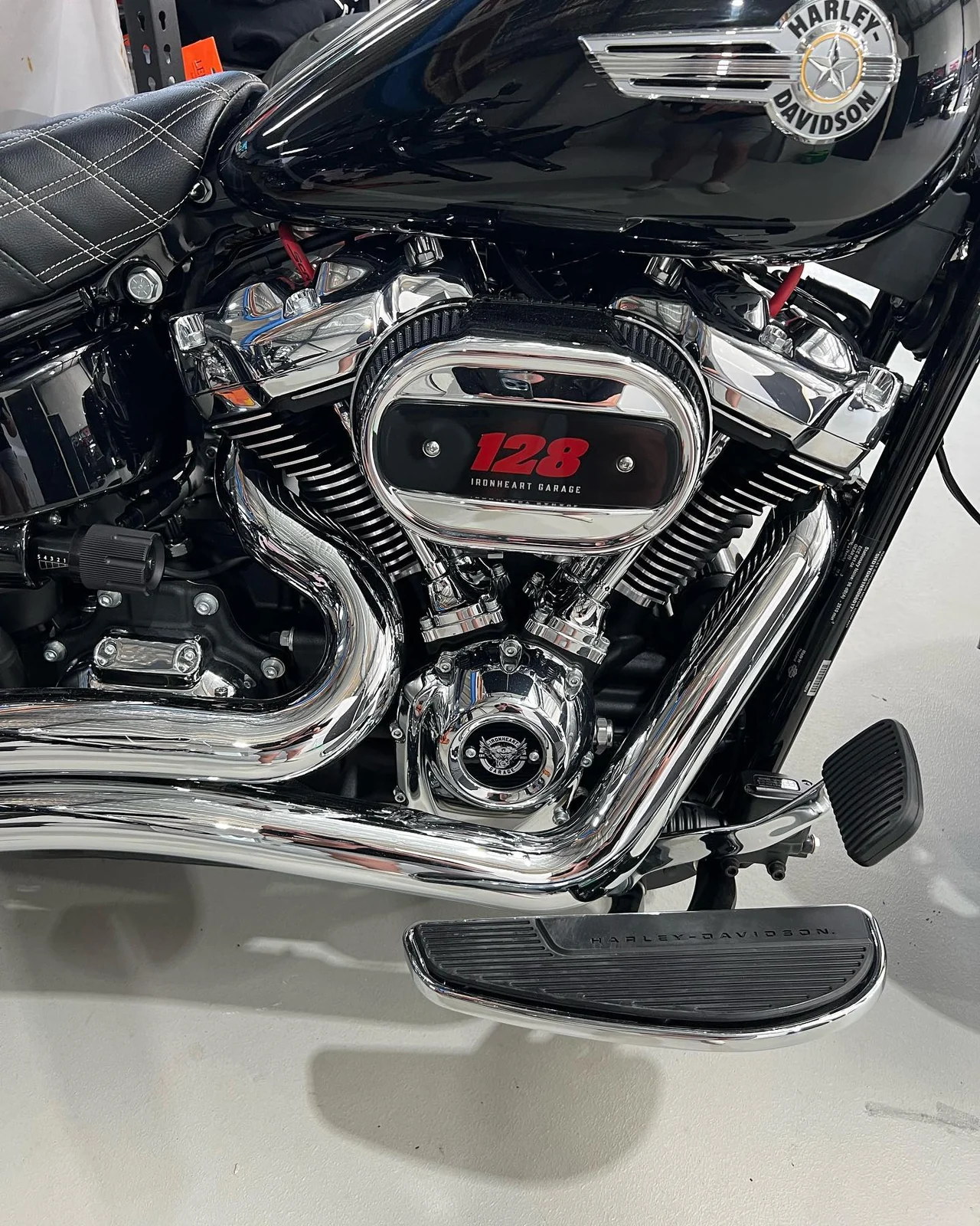 Custom black motorcycle insert with red 128 lettering fitted to a Harley-Davidson motorcycle