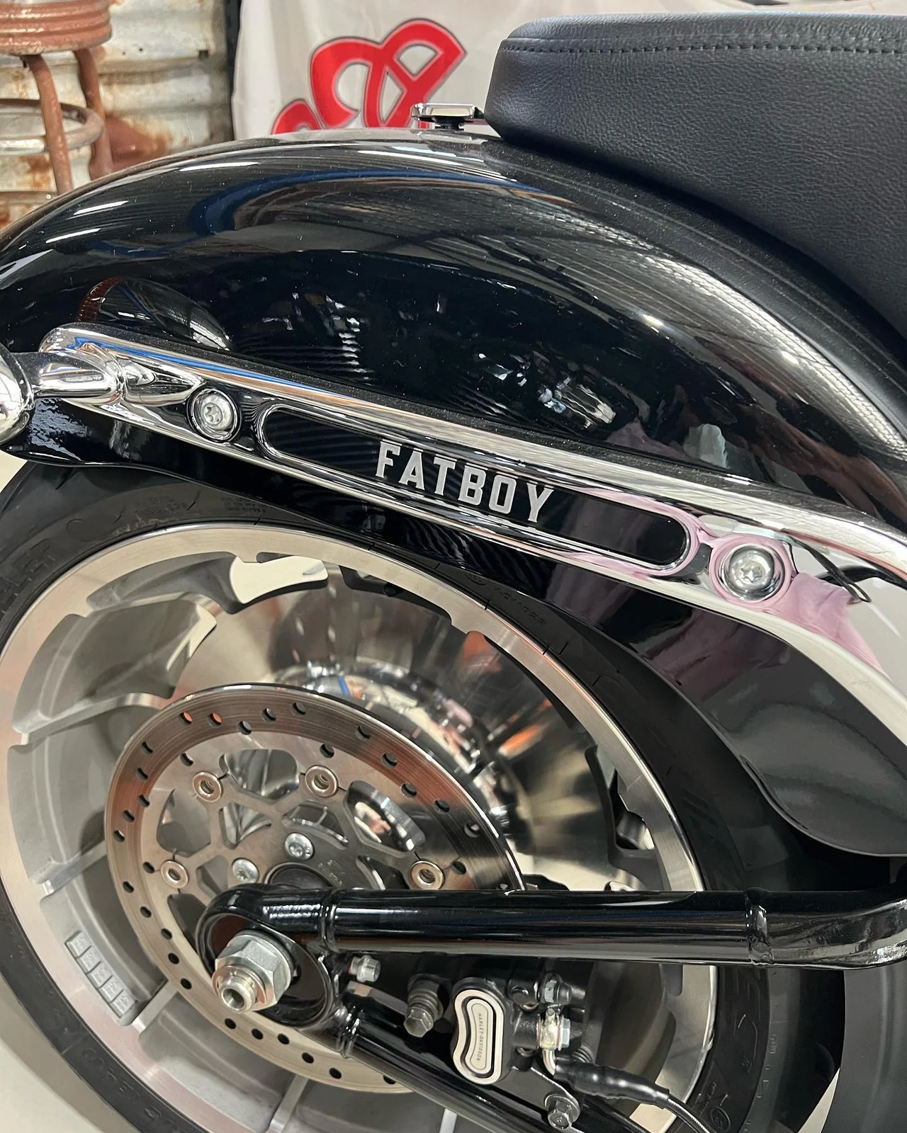 Custom FATBOY rear fender strut insert fitted above a motorcycle wheel