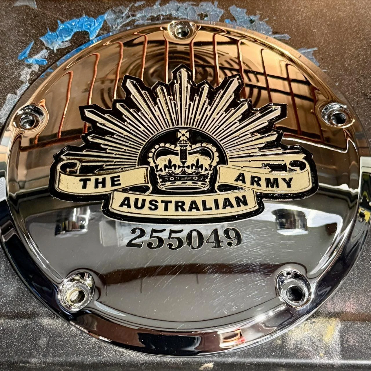 Chrome motorcycle derby cover engraved with an Australian Army themed design